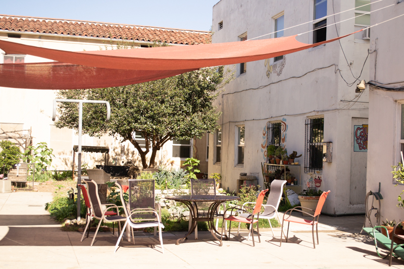 A covered patio with lawn furniture.