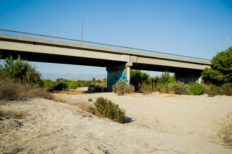 A freeway that goes over a dry part of the river.